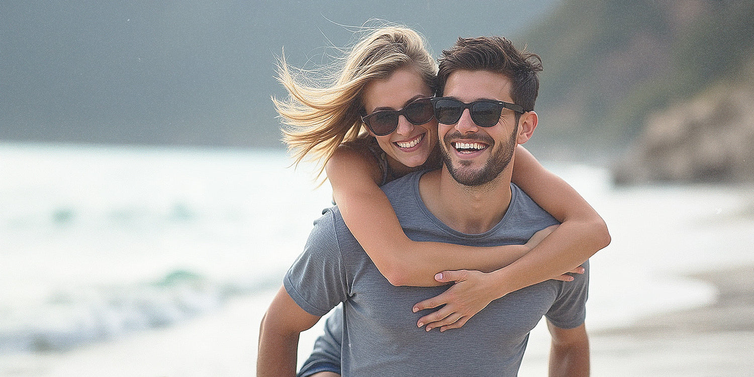 Happy couple on the beach huging and laughing