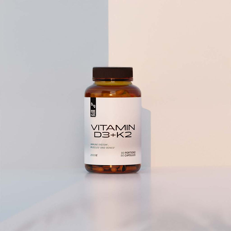 Vitamin D3+K2 supplement bottle on a two-tone background