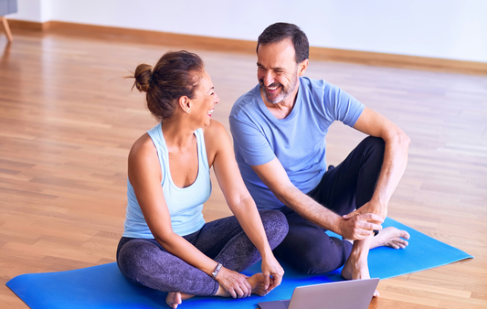 Happy couple sitting in a training yoga room