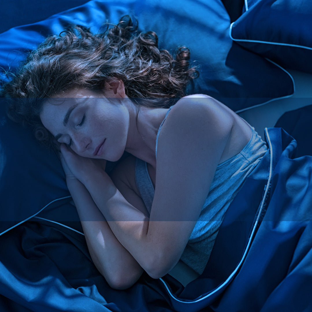 Frau schläft im bett mit blauer Bettwäsche - Beyond Nutrition
