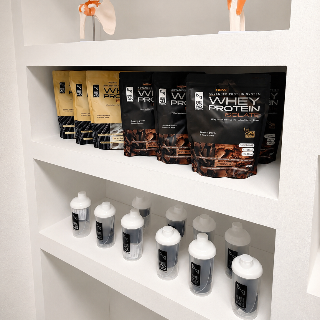 Shelf display of Beyond Nutrition Whey Protein powder bags and shaker bottles in a clean white indoor setting.