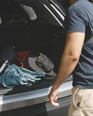 Person organizing items in a car trunk