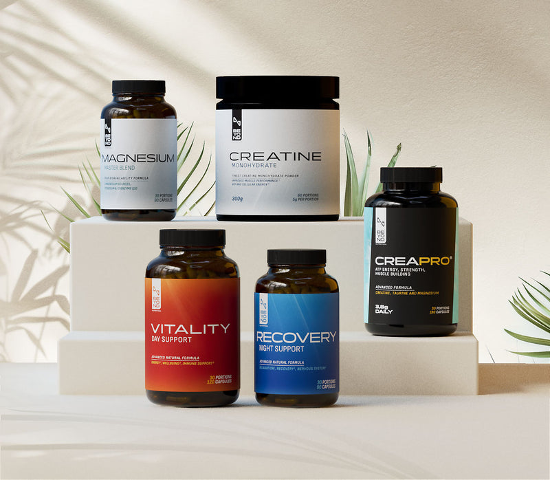 Collection of supplement bottles on a neutral background with plants