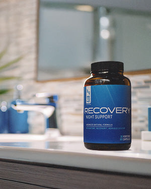 Supplement bottle labeled 'Recovery Night Support' on a bathroom counter from beyond Nutrition.