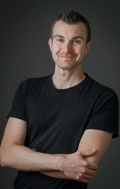 Man wearing a black t-shirt against a dark background